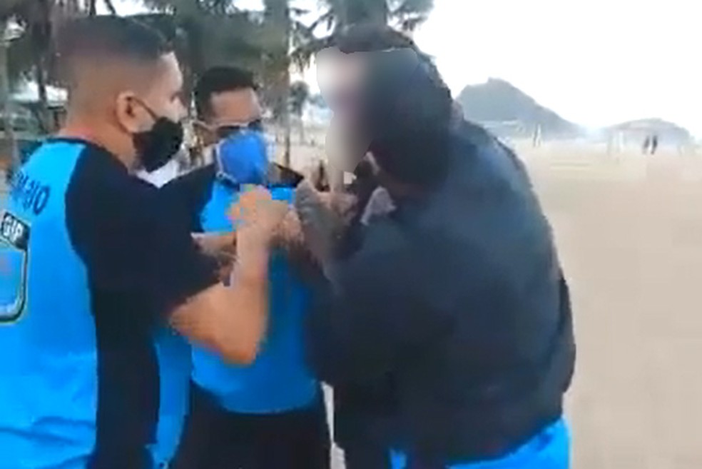 Guardas tentam imobilizar homem que resiste a abordagem na Praia de Copacabana — Foto: Reprodução