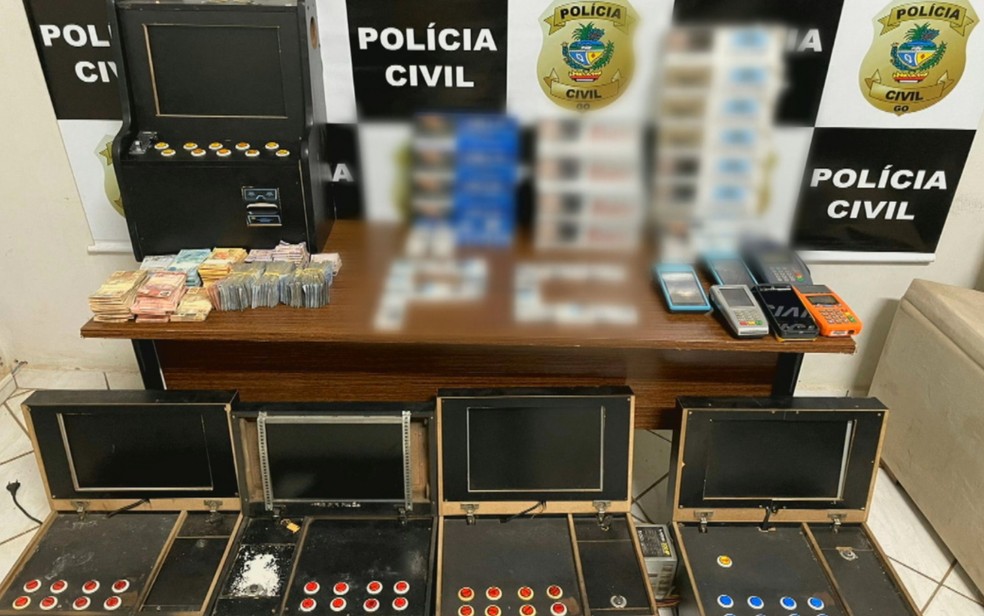 Caça-níqueis, dinheiro e máquinas de cartões apreendidas em bar de Anápolis — Foto: Reprodução/TV Anhanguera