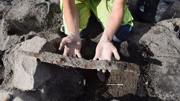 Espada é levantada, depois de passar séculos presa ao chão  — Foto: Reprodução /  The Archaeologists/National Historical Museums