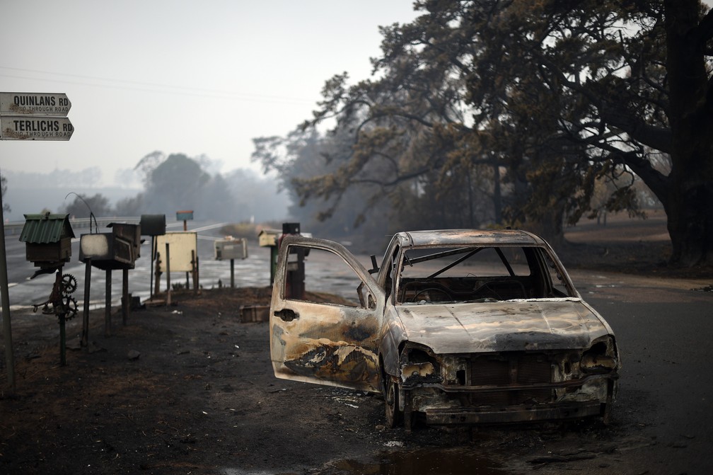 6 de janeiro  - Um carro destruído por incêndios florestais é visto em Quaama, no estado de Nova Gales do Sul, na Austrália — Foto: Saeed Khan/AFP