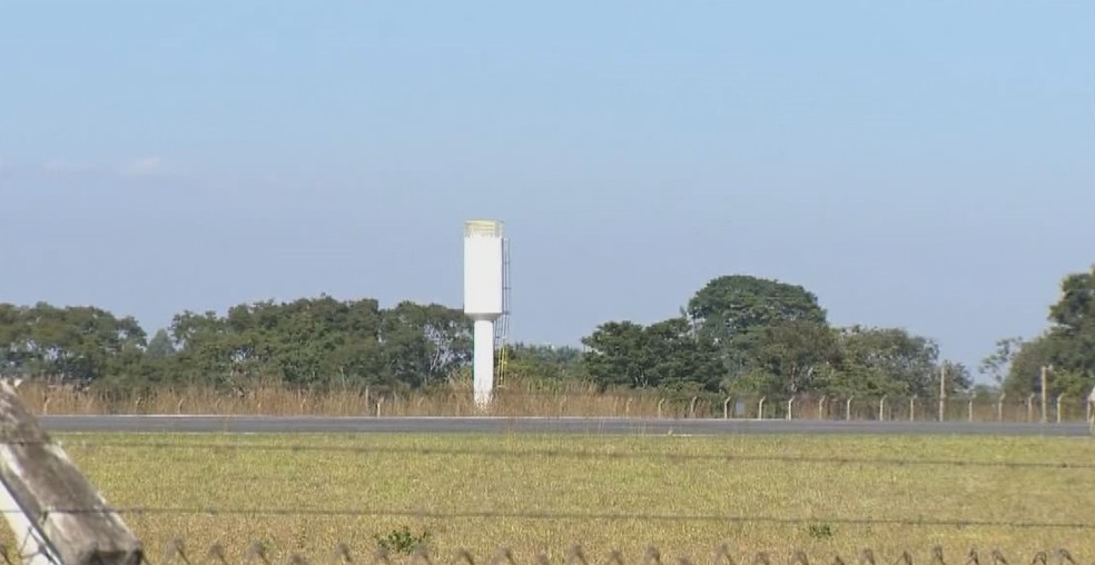 Caixa d'água próxima da cerca da pista do aeroporto de Patos de Minas é um dos problemas — Foto: Reprodução/TV Integração