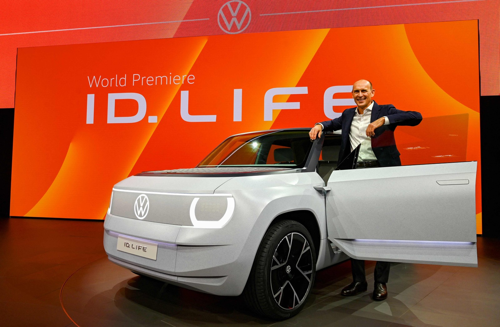 O gerente da Volkswagen, Ralf Brandstaetter, posa ao lado de um carro elétrico da marca o  VW ID.LifeCHRISTOF STACHE/AFP