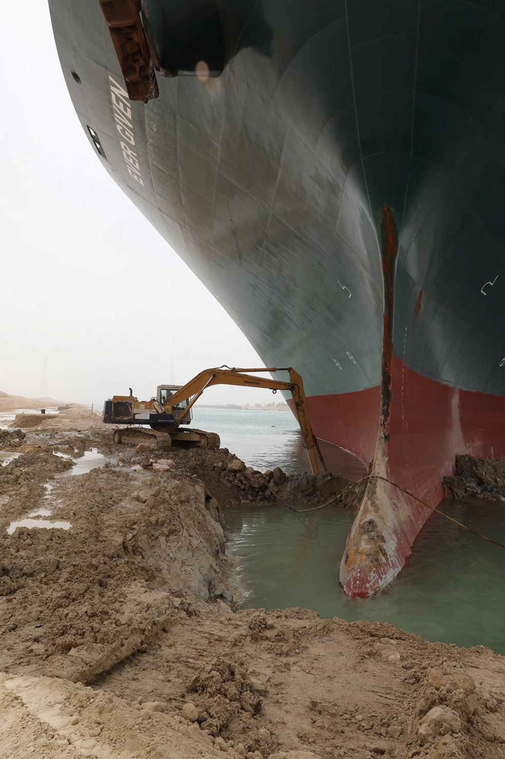 Escavadeira usada para tirar a terra em volta do proa do meganavio Ever Given, um dos maiores navios de contêiner do mundo, que encalhou no Canal de Suez, no Egito — Foto: Autoridade do Canal de Suez/Reuters