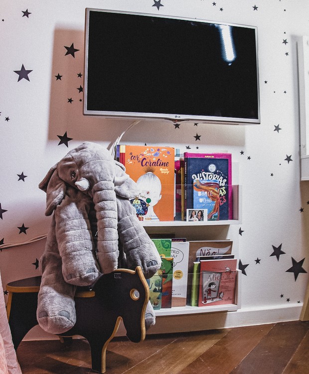 Estantes para livros, banquinho em formato de cavalo e televisão: quarto tem tudo que a menina precisa  (Foto: Matheus Pinho / Divulgação)