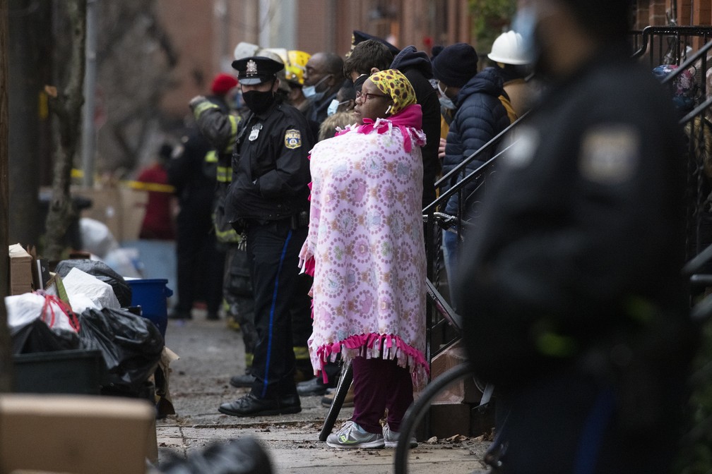 Multidão assiste ao trabalho dos bombeiros no local de um incêndio que deixou 13 mortos em uma casa geminada no bairro de Fairmount, na Filadélfia, em 5 de janeiro de 2022 nos Estados Unidos — Foto: Alejandro A. Alvarez/The Philadelphia Inquirer via AP