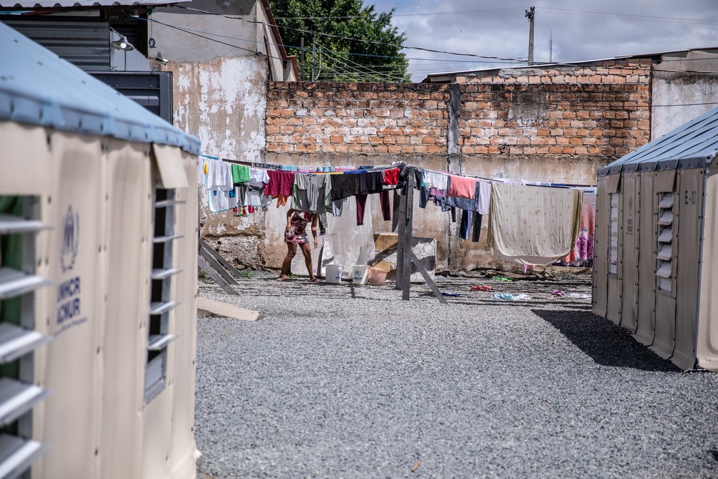 Mulher estende roupas lavadas no varal de um abrigo da Operação Acolhida em Boa Vista — Foto: Fábio Tito/g1