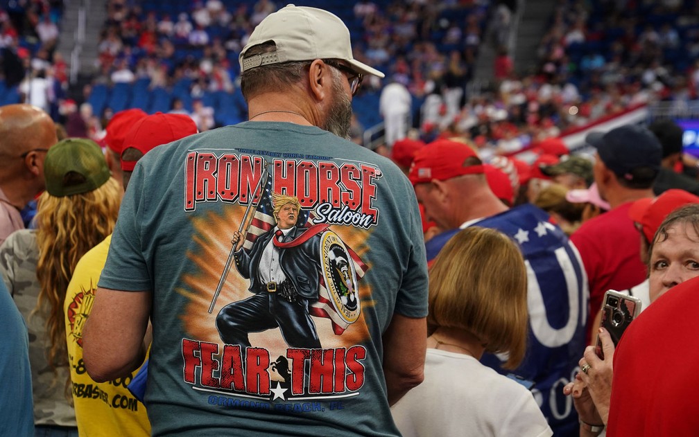 Homem exibe camiseta em homenagem a Trump, no Amway Center, em Orlando, na Flórida, no dia do lançamento da campanha de reeleição do presidente, na terça-feira (18) — Foto: Reuters/Carlo Allegri