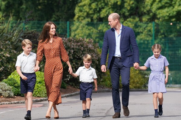 O Príncipe Louis de mãos dadas apenas com a mãe, a Duquesa Kate Middleton, após recusar a mão do pai, o Príncipe William, durante a ida da família para o primeiro dia dele e dos irmãos, Príncipe George e Princesa Charlotte, na Lambrook School (Foto: Getty Images)