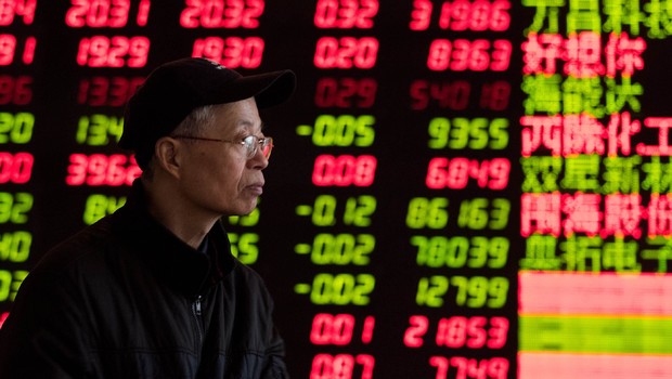 Investidor observa painel na Bolsa de Valores de Xangai ; ações chinesas ; mercado financeiro asiático ;  (Foto: ChinaFotoPress/Getty Images)