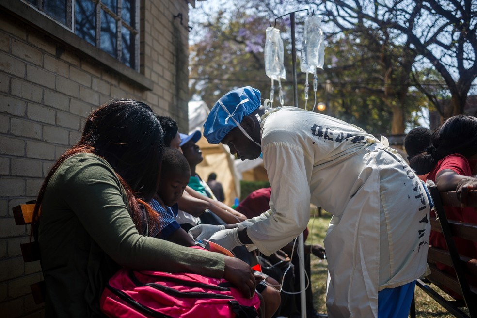 População recebe tratamento para cólera no Zimbábue.  — Foto: Jekesai NJIKIZANA / AFP