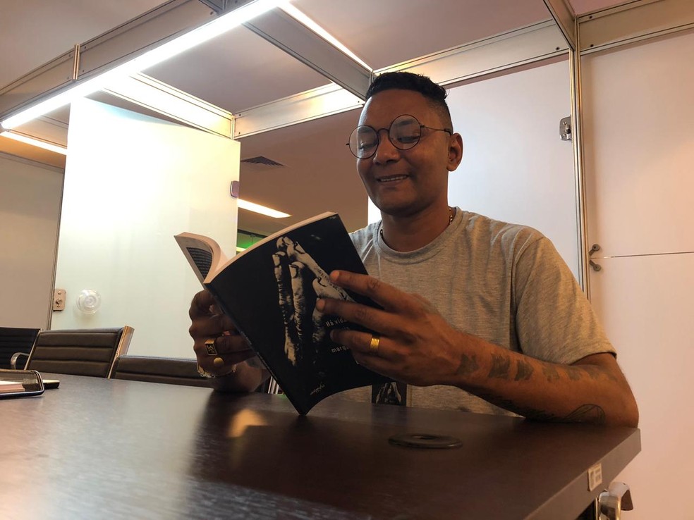 O escritor Léo Motta lê seu primeiro livro, ‘A vida depois da marquise',  lançado na Bienal do Rio  — Foto: Carlos Brito/G1