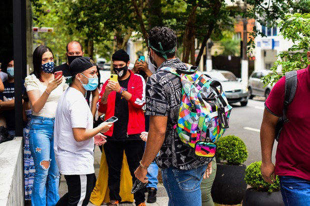 Arcrebiano conversa e posa com fãs ao chegar a flat (Foto: Leo Franco/AgNews)