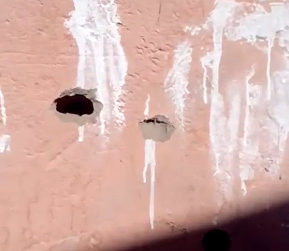 Moradora mostra uma marca de bala na parede de seu quarto, em Anchieta — Foto: Reprodução