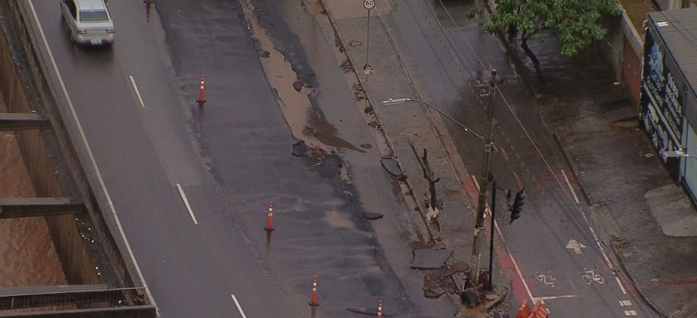 Parte do asfalto da Avenida Tereza Cristina foi arrancada pela enxurrada — Foto: Reprodução/TV Globo