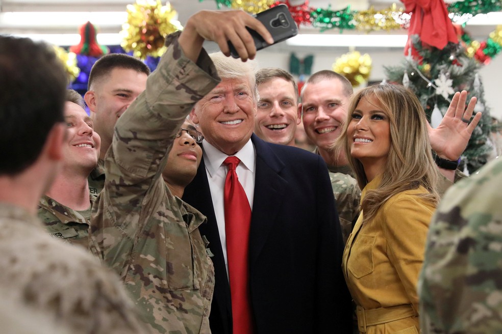 Militar norte-americana faz selfie com Donald Trump e Melania durante visita do presidente ao Iraque — Foto: Jonathan Ernst/Reuters