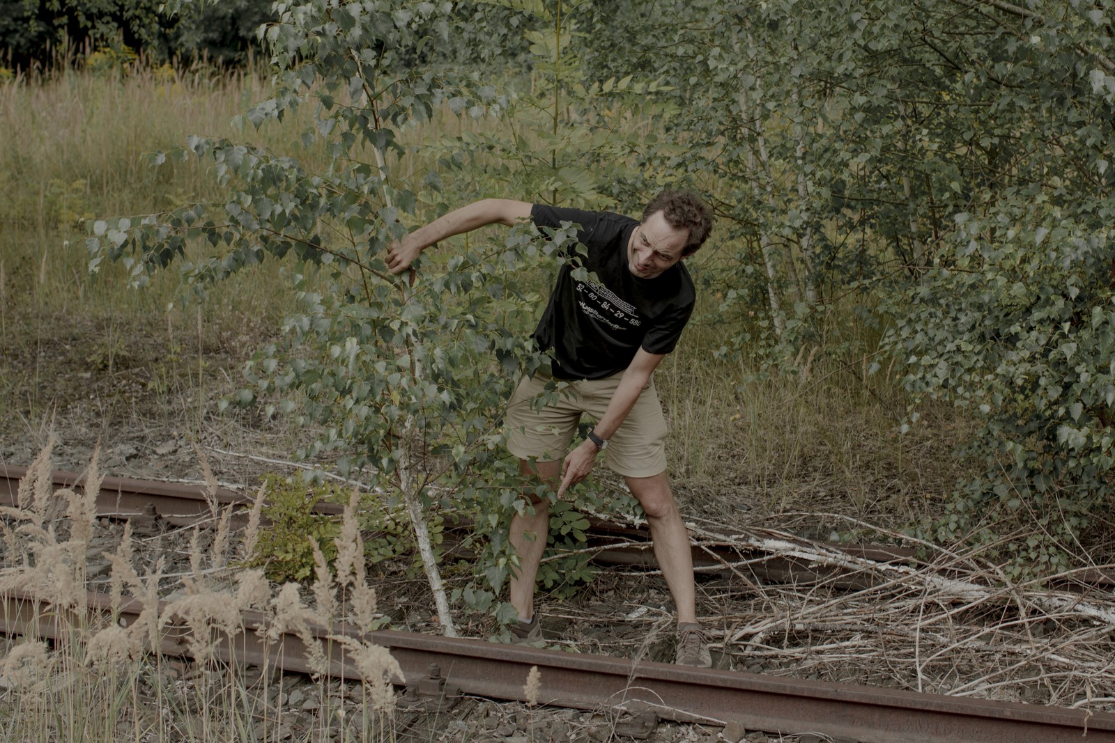Jon Worth examina trilhos de trem cobertos de vegetação em Seifhennersdorf, Alemanha — Foto: Emile Ducke/The New York Times