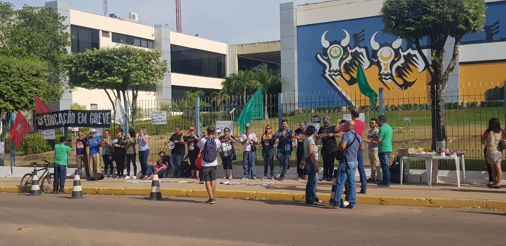 Servidores da Educação em greve se acorrentam em protesto na frente da sede do governo em Cuiabá — Foto: Tiago Terciotty/TV Centro América