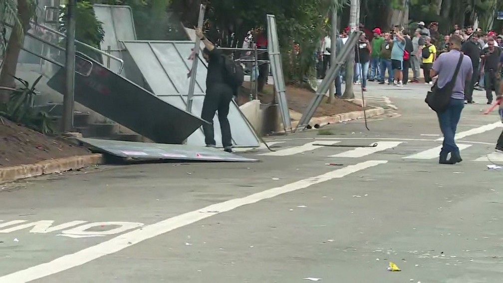 Manifestantes usam placas de aço para se proteger de bombas lançadas pela PM na Alesp — Foto: Reprodução/GloboNews