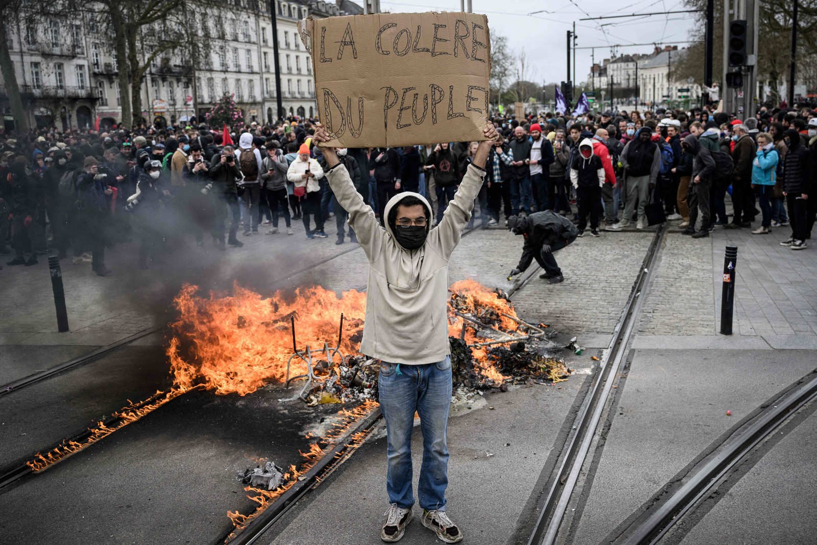 "A raiva do povo", diz cartaz segurado por manifestante em protesto contra a recém aprovada reforma previdenciária feita pelo governo francês — Foto: LOIC VENANCE / AFP