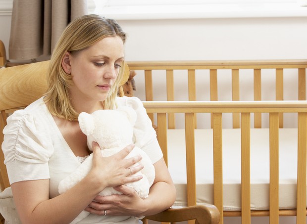 Aborto espontâneo; mulher triste no quarto do bebê (Foto: Shutterstock)