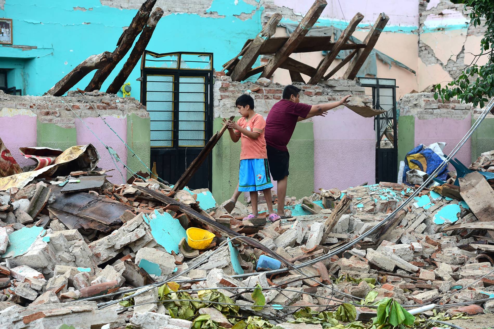 Moradores procuram pertences em meio às ruínas de sua casa após terremoto, em Juchitan, Oaxaca, no México