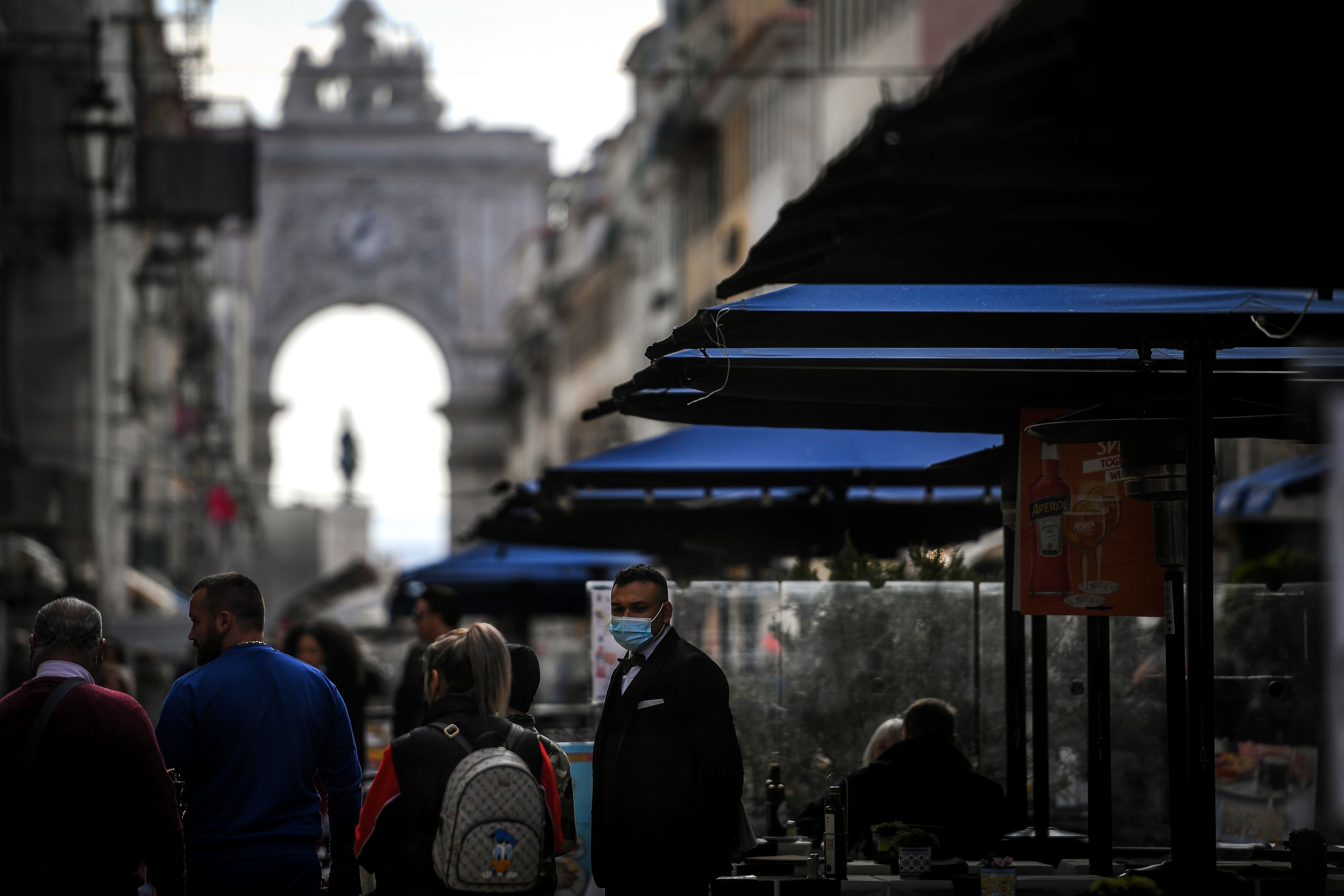 Garçom de máscara aguarda clientes em um restaurante no centro de Lisboa