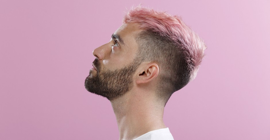 A profile of man with pink hair, taken in front of a pink backdrop. (Foto: Getty Images)