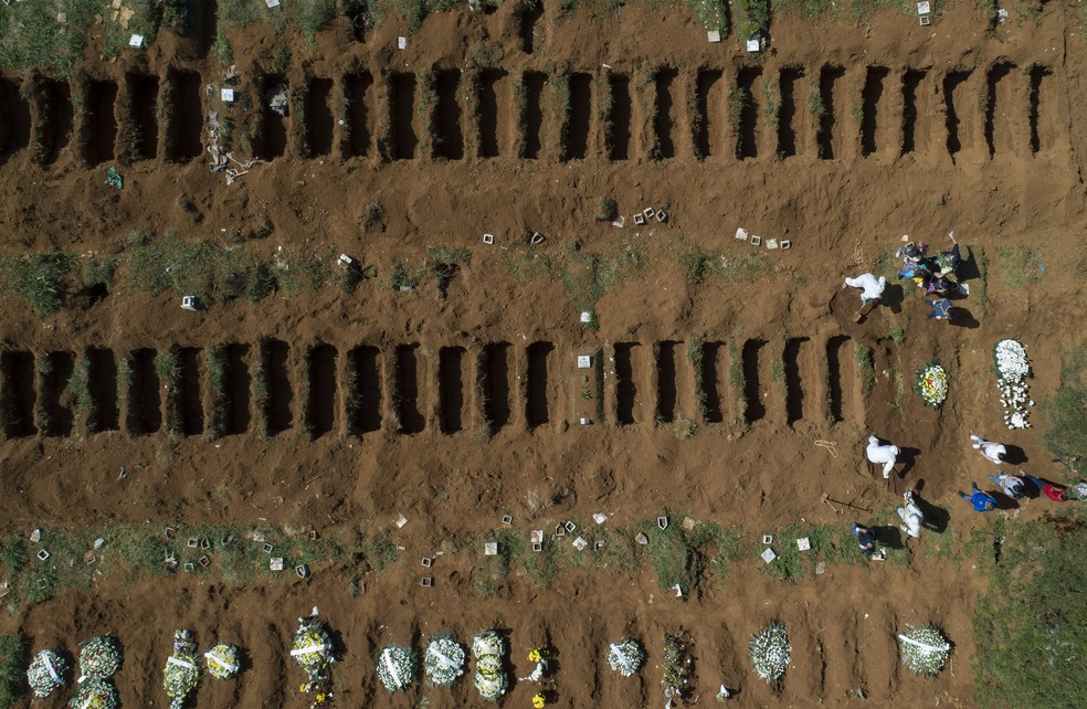 1º de abril - Vista aérea de funcionários cavando túmulos no cemitério da Vila Formosa, em São Paulo — Foto: Andre Penner/AP