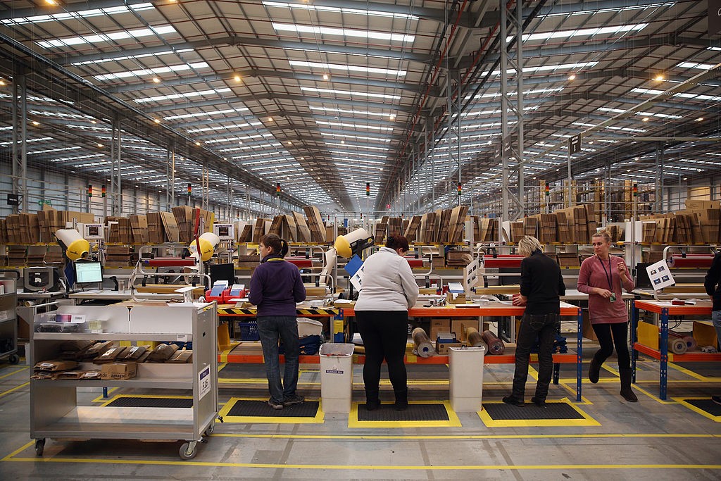 PETERBOROUGH, ENGLAND - NOVEMBER 28:  Employees gift wrap items before dispatching them in the huge Amazon 'fulfilment centre' warehouse on November 28, 2013 in Peterborough, England. The online retailer is preparing for 'Cyber Monday', as it predicts tha (Foto: Getty Images)
