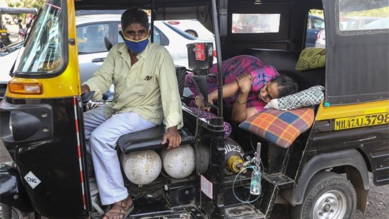 Mulher deitada à espera de assistência médica; Delhi tem uma das melhores instalações de saúde da Índia, mas chegou a mais de 99% dos leitos de terapia intensiva ocupados (Foto: EPA via BBC)