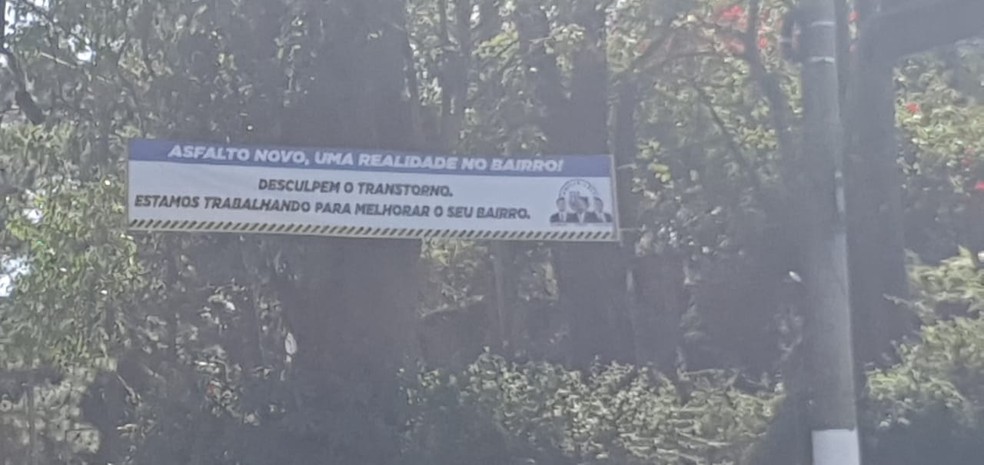 Faixa de propaganda colocada na Estrada de Parelheiros informando sobre obras de asfaltamento na região, com as imagens da família do vereador Milton Leite (DEM). — Foto: Acervo Pessoal
