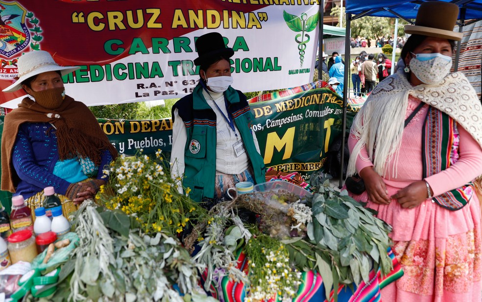 Curandeiras usam máscaras em estande de venda de ervas medicinais em mercado de rua em La Paz, na Bolívia, em foto de 26 de janeiro — Foto: AP Photo/Juan Karita