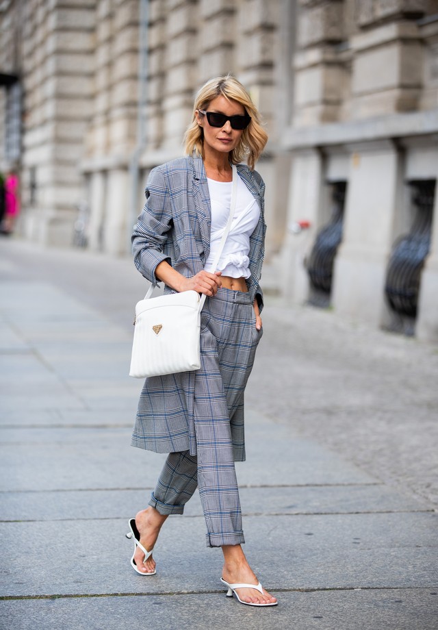 BERLIN, GERMANY - JULY 22: Gitta Banko is seen wearing grey checked pants and checked oversize-fitted coat by Steffen Schraut , white shirt from thelinebyK, white patent leather flip flops with white heels, snowwhite Dakar crossover bag in canvas with gol (Foto: Getty Images)
