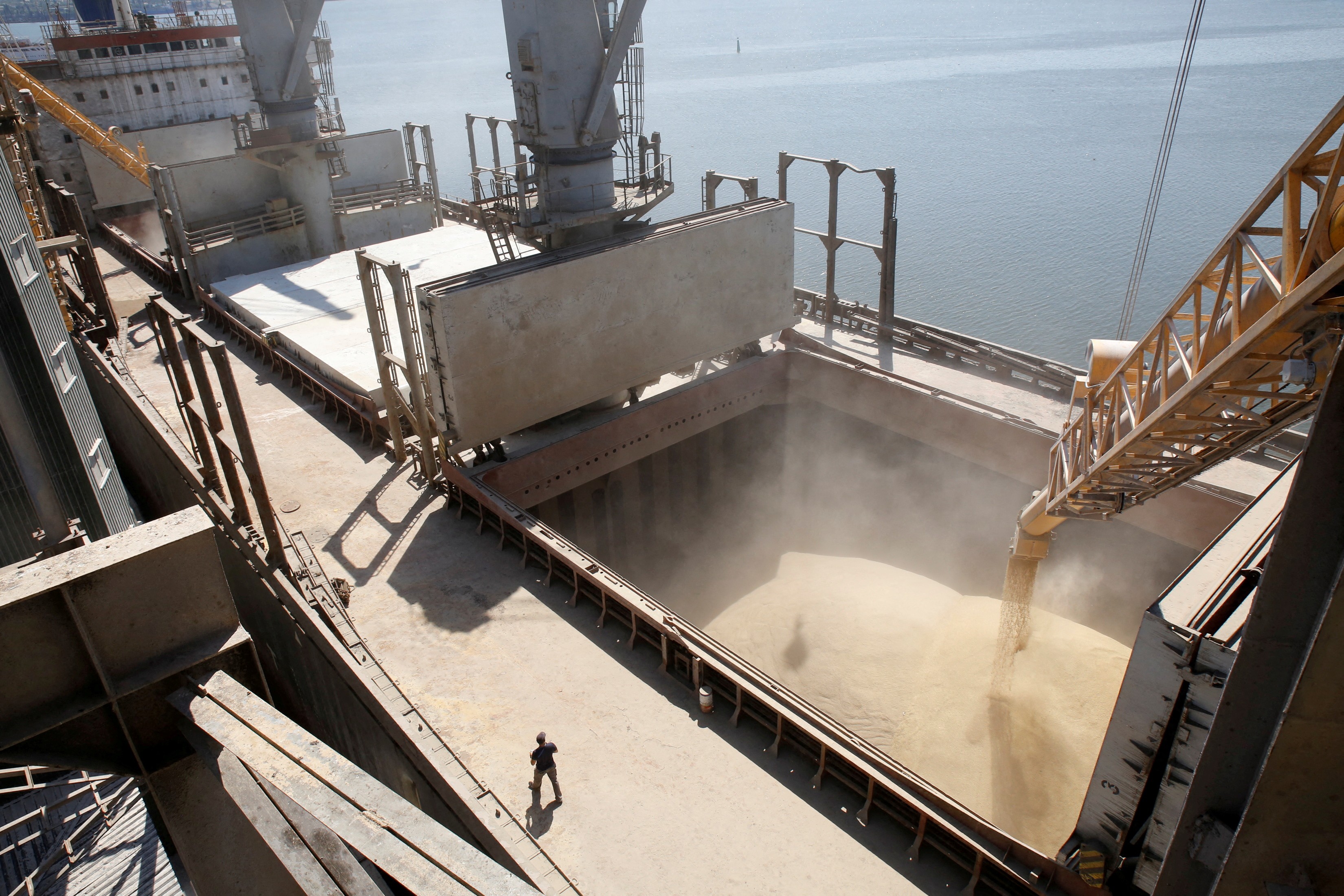 Trabalhador do estaleiro observa grãos de cevada sendo despejados em um navio em Nikolaev (Foto: REUTERS/Vincent Mundy)