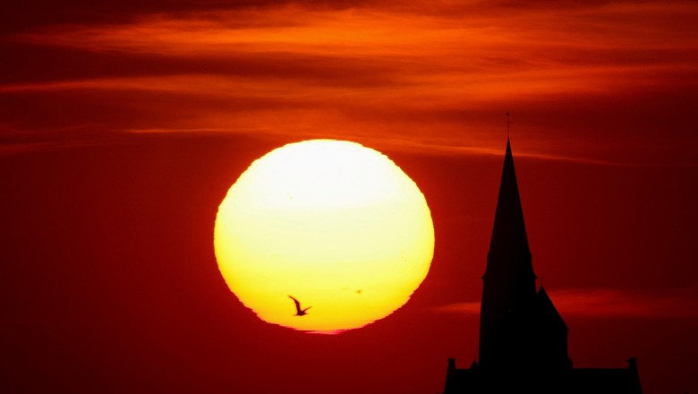 Vista de igreja durante o pôr do sol em Oisy-le-Verger, na França, em meio a onda de calor que atinge Europa (Foto: REUTERS/Pascal Rossignol)