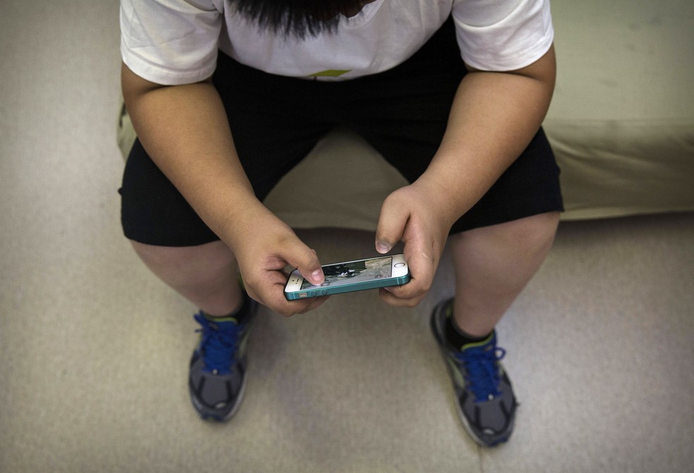 Passar muito tempo em frente à TV e celular contribui para aumento de peso nas crianças (Foto: Getty Images)