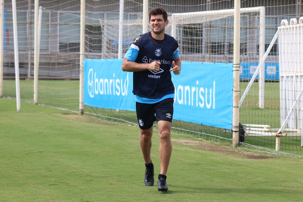 Kannemann corre em torno do gramado em treino do Grêmio — Foto: João Victor Teixeira/ge