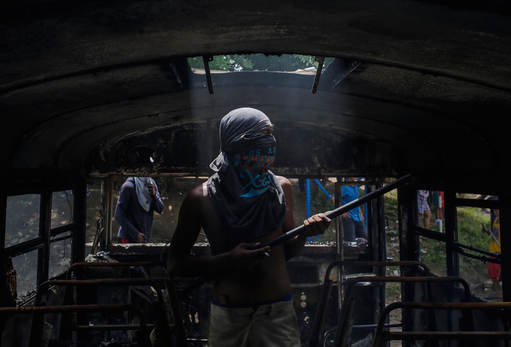 Manifestante Ã© visto dentro de Ã´nibus incendiado durante greve nacional na NicarÃ¡gua (Foto: Inti Ocon/AFP)