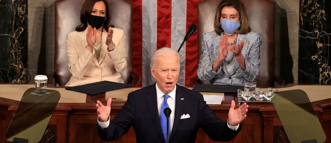Joe Biden discursa em sessão conjunta do Congresso enquanto a vice-presidente Kamala Harris e a presidente da Câmara, Nancy Pelosi, aplaudem no Capitólio em Washington