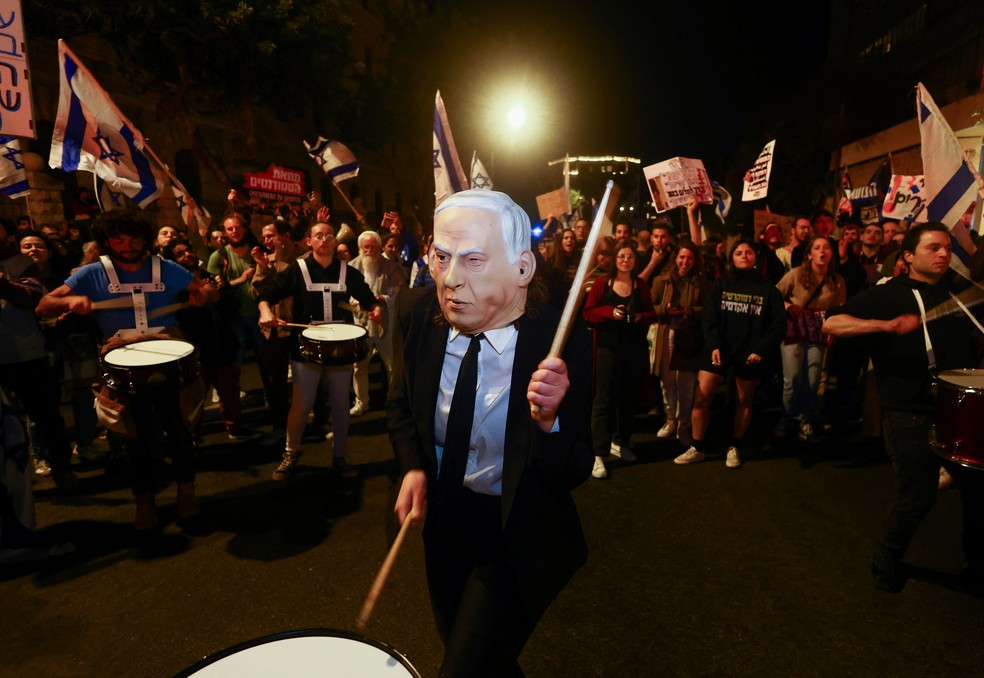 Manifestante usa máscara ironizando Benjamin Netanyahu em protesto em Jerusalém. — Foto: REUTERS/Ronen Zvulun