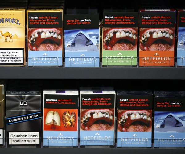 Maços de cigarro com capas contendo ilustrações que simulam bocas e dentes danificados pelo uso de cigarro. A União Europeia está discutindo novas regras para venda de derivados de tabaco. A previsão é que, até 2015, todos os maços tenham 75% do seu espaço em ambos os lados com imagens de alerta para os riscos do fumo (Foto: Fabrizio Bensch/Reuters)