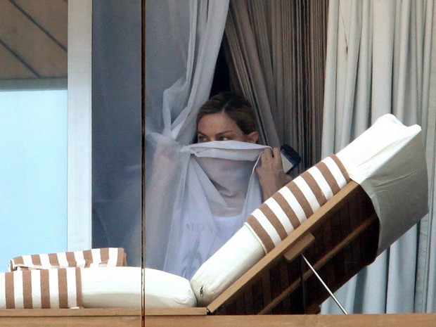 Madonna dá uma espiadinha pela janela de hotel, mas fica atrás da cortina  (Foto: Fabio Rossi / Agência O Globo )