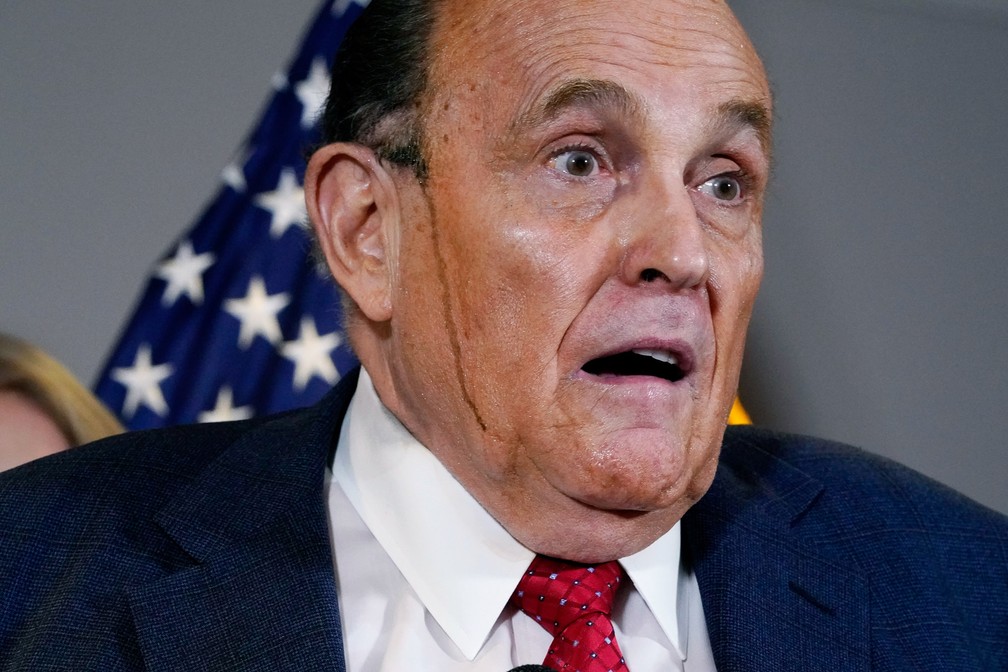 19 de novembro - Suor misturado a tinta para cabelo escorre pelo rosto de Rudy Giuliani, advogado de Donald Trump, durante entrevista coletiva em que insistia em acusar, sem provas, as eleições americanas de fraudadas — Foto: Jacquelyn Martin/AP