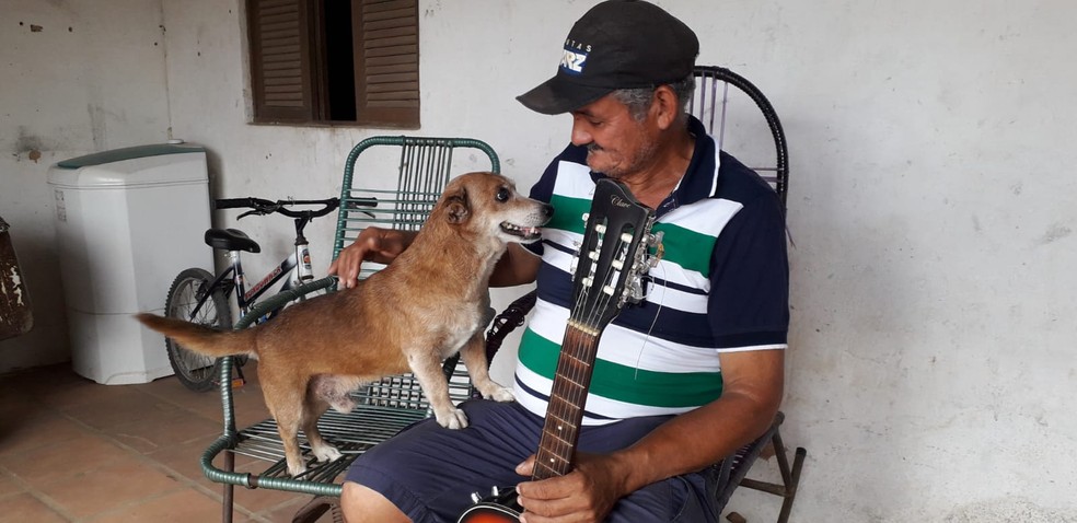 Pedreiro Alcides Soares, de 57 anos, comemora resgate do cachorro Quinho de inc&ecirc;ndio que destruiu a casa onde eles moravam, em Natal &mdash; Foto: Kl&ecirc;nyo Galv&atilde;o/Inter TV Cabugi