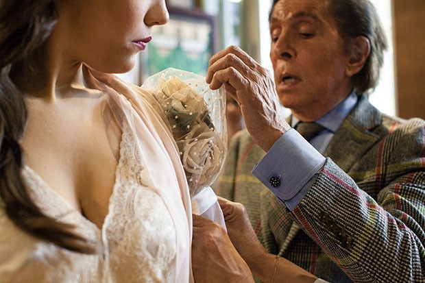 Valentino applies the finishing touches to a gown worn by Violetta (Francesca Dotto) before the premier of La Traviata in Rome's Teatro dell'Opera (Foto: Valentino)