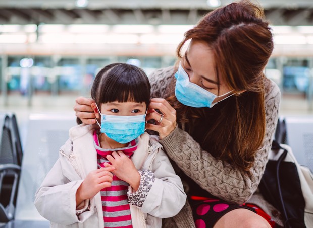 Mãe colocando máscara em criança (Foto: Getty Images)