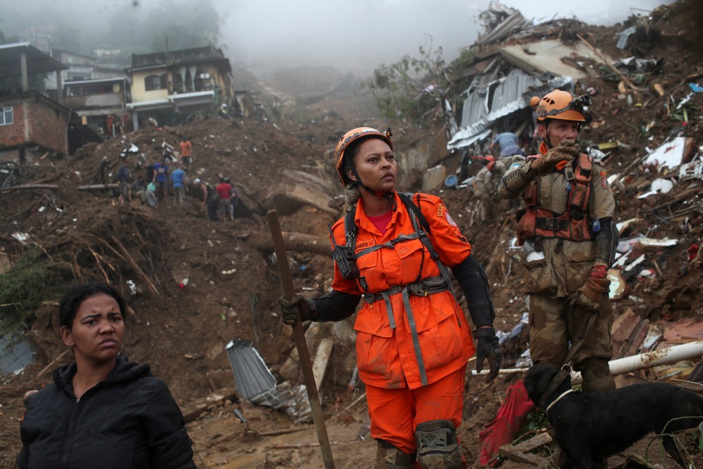 Bombeiros e moradores procuram por vítimas após deslizamento no Morro da Oficina, em Petrópolis (RJ), nesta quarta (16) — Foto: Ricardo Moraes/Reuters