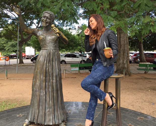 Com o chimarrão na mão, Carol Nakamura 'canta' com a estátua de Elis Regina (Foto: Arquivo Pessoal)