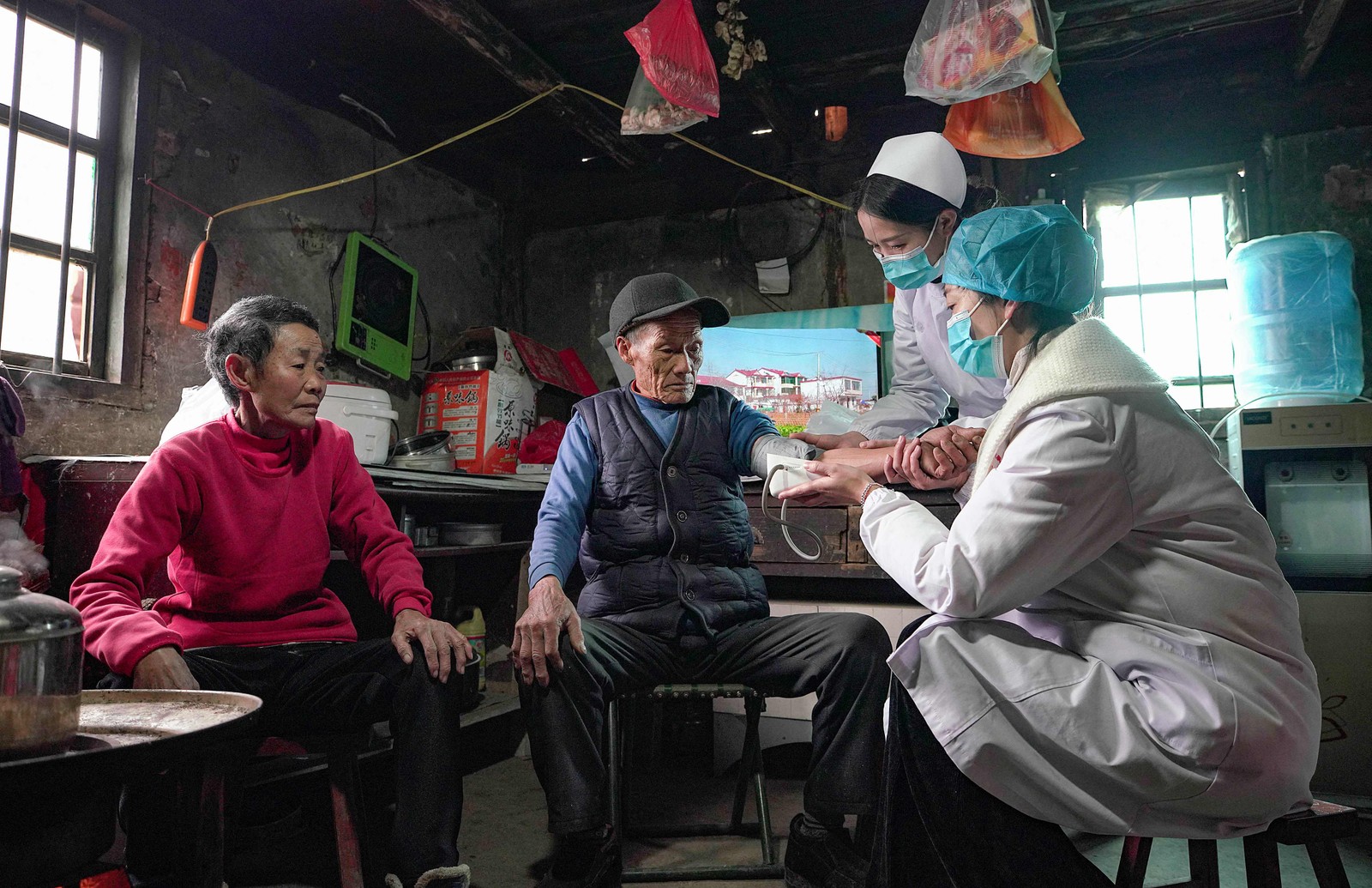 Profissionais de saúde fazem atendimento médico em domicílio na província de Guizhou, sudoeste da China, para pessoas que não podem sair facilmente de suas casas.  — Foto: AFP / China OUT 