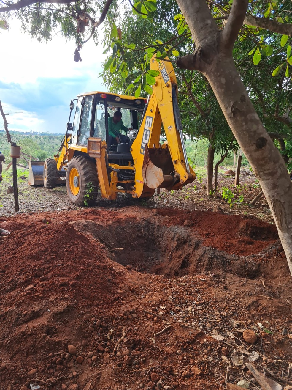 Escavadeira retira ossada da vítima encontrada na propriedade rural — Foto: Polícia Civil/Cedida